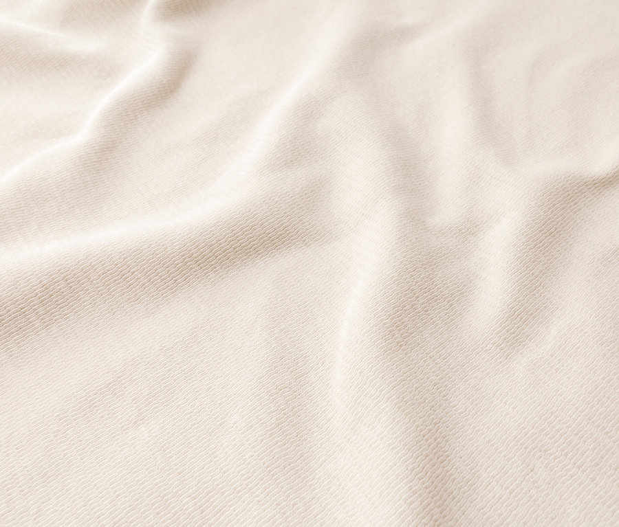 Gros plan d'un tissu crème drapé.