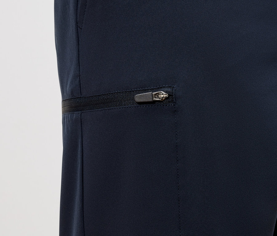 Gros plan sur un pantalon bleu marine avec une fermeture éclair horizontale sur la poche.