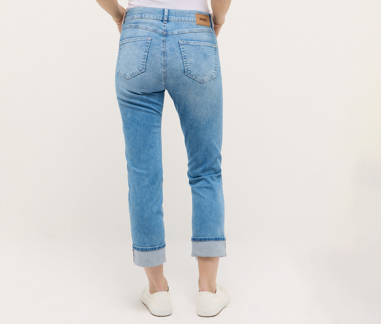 Une personne porte un jean Angels Denim « Cira Boho » et des chaussures blanches.