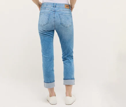 Une personne porte un jean Angels Denim « Cira Boho » et des chaussures blanches.