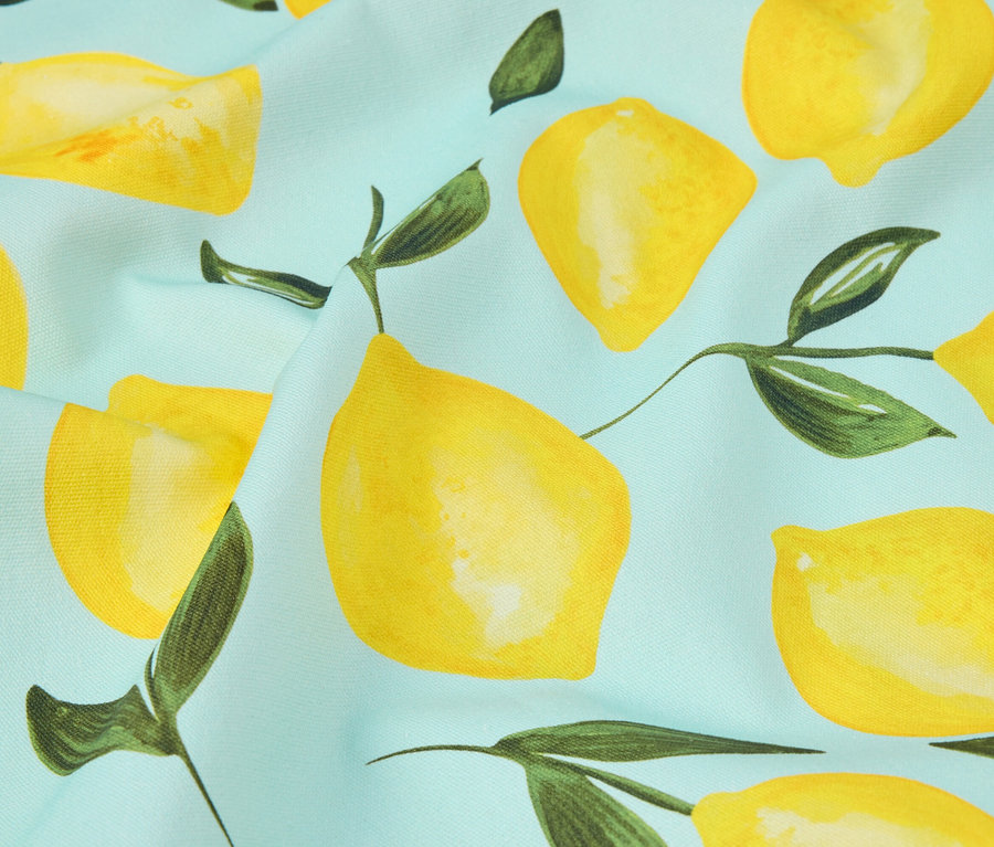 Gros plan d'un tissu bleu clair avec un motif de citrons.