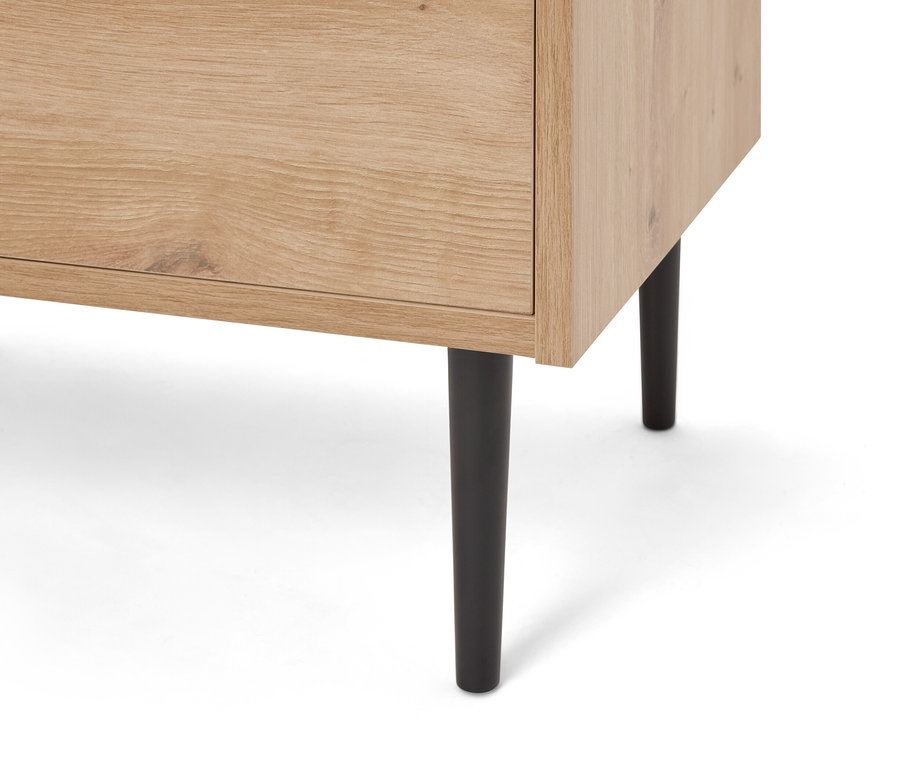 Gros plan d'une armoire en bois marron clair avec des pieds noirs.