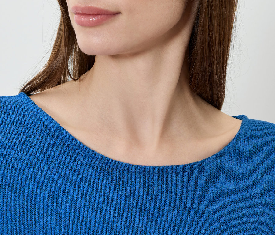 Gros plan d'une femme portant un pull bleu.