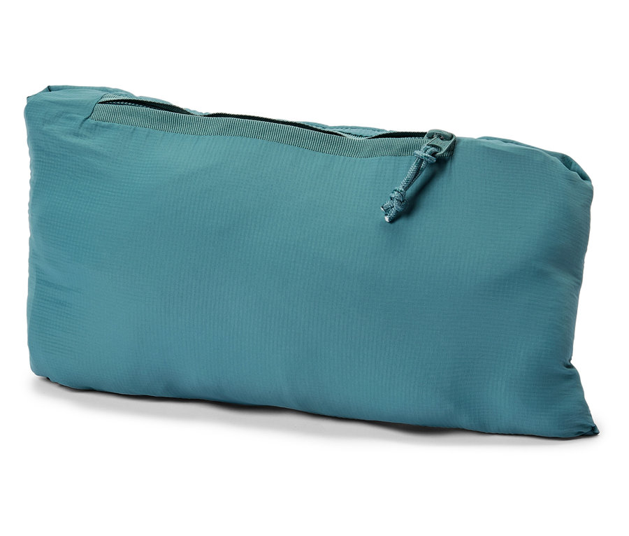 Gros plan d'une veste pliée turquoise et verte avec une fermeture éclair sur un fond blanc.