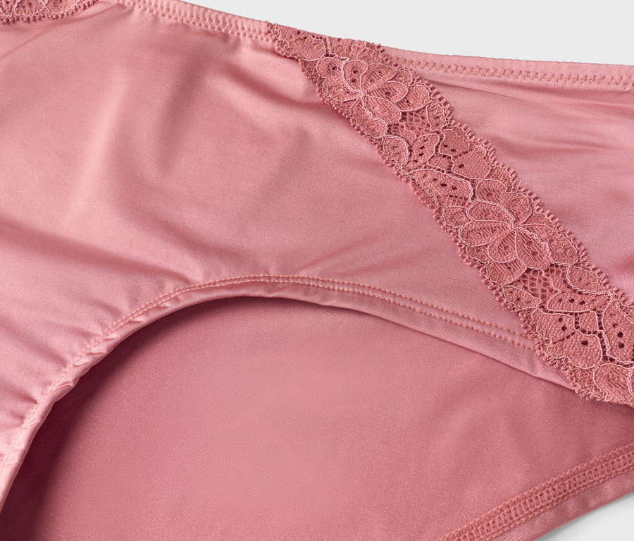 Gros plan sur une culotte rose pour femme avec des détails en dentelle.