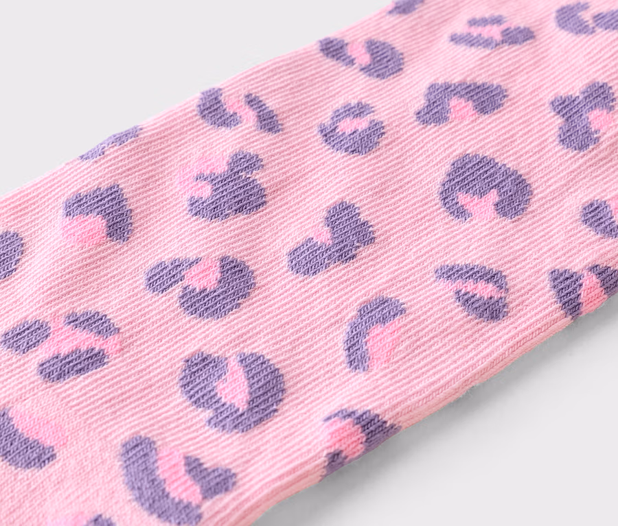 Gros plan sur un tissu rose à motif léopard violet.