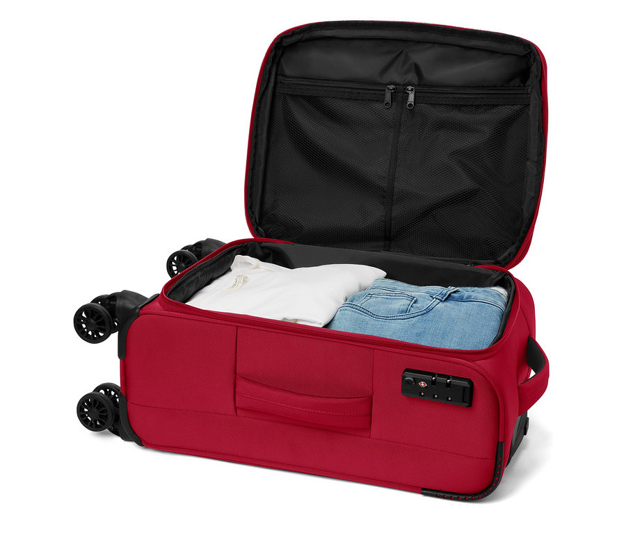 Valise rouge ouverte à roulettes avec un t-shirt blanc et un jean à l'intérieur.