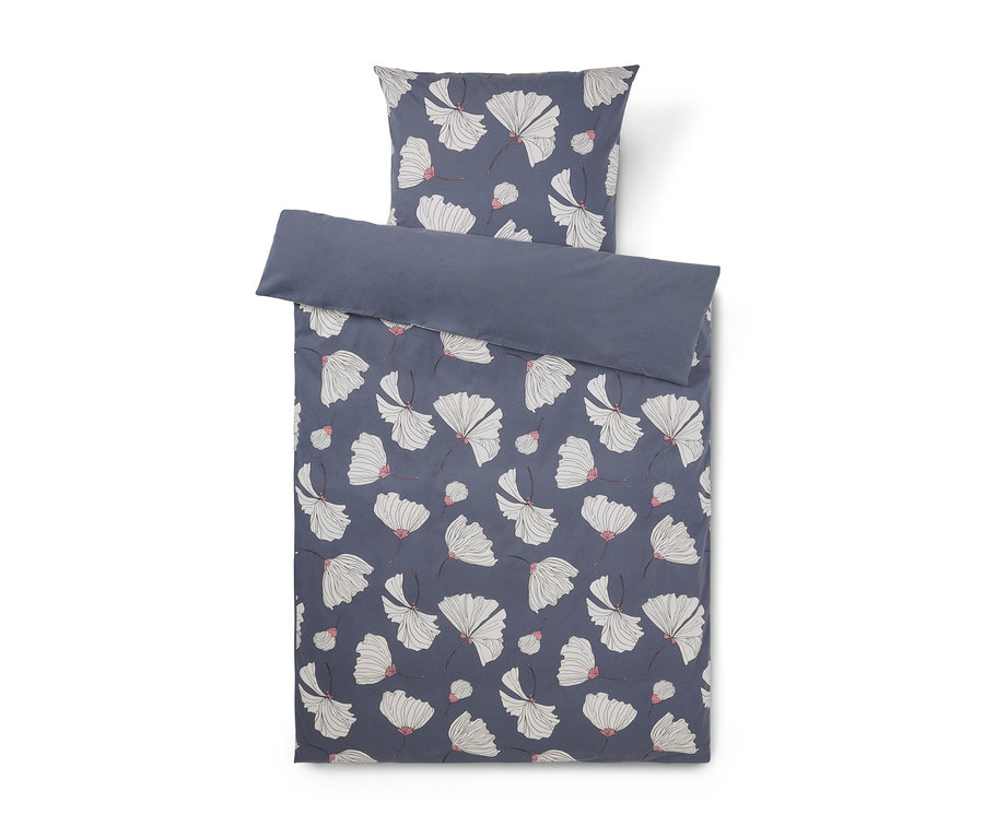 Parure de lit bleu foncé avec housse de couette et taie d'oreiller, ornée d'un motif de fleurs blanches en éventail avec des accents roses. La housse de couette est pliée, révélant un dessous uni bleu foncé.