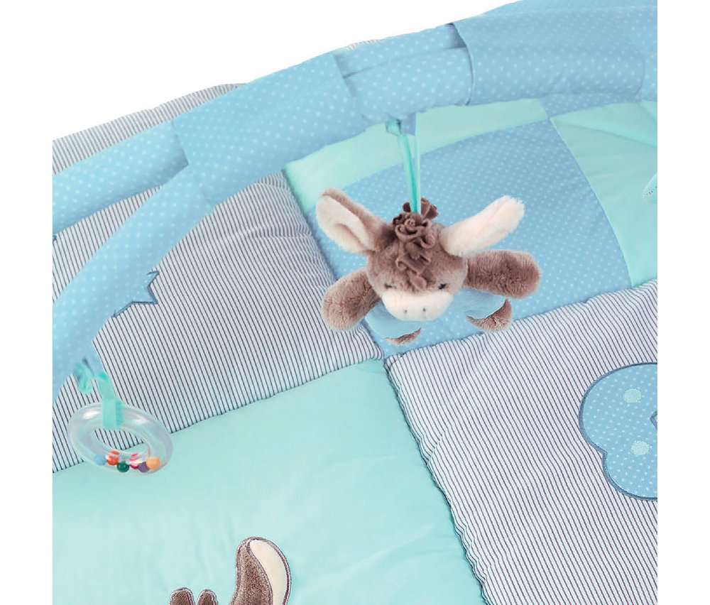 Gros plan sur un tapis d'éveil bleu pour bébé avec des motifs rayés et à pois, d'où pendent un âne en peluche et un anneau de dentition avec des perles colorées.