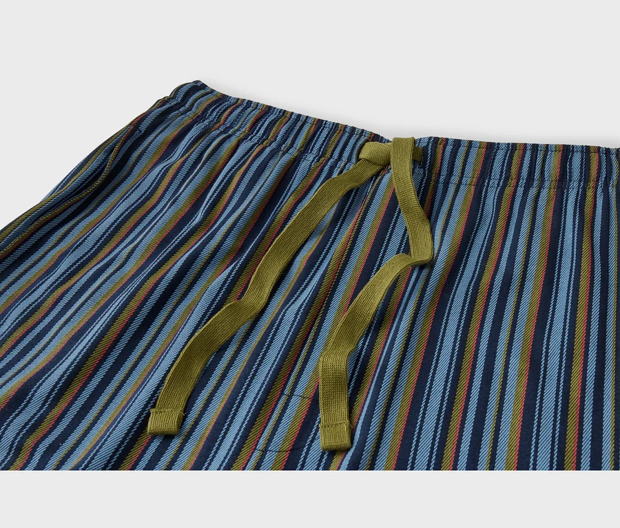 Gros plan d'un pantalon rayé avec une taille élastique et un cordon de serrage vert olive. Le pantalon présente des rayures verticales dans des tons de bleu, vert olive et une touche de rouge-orangé.
