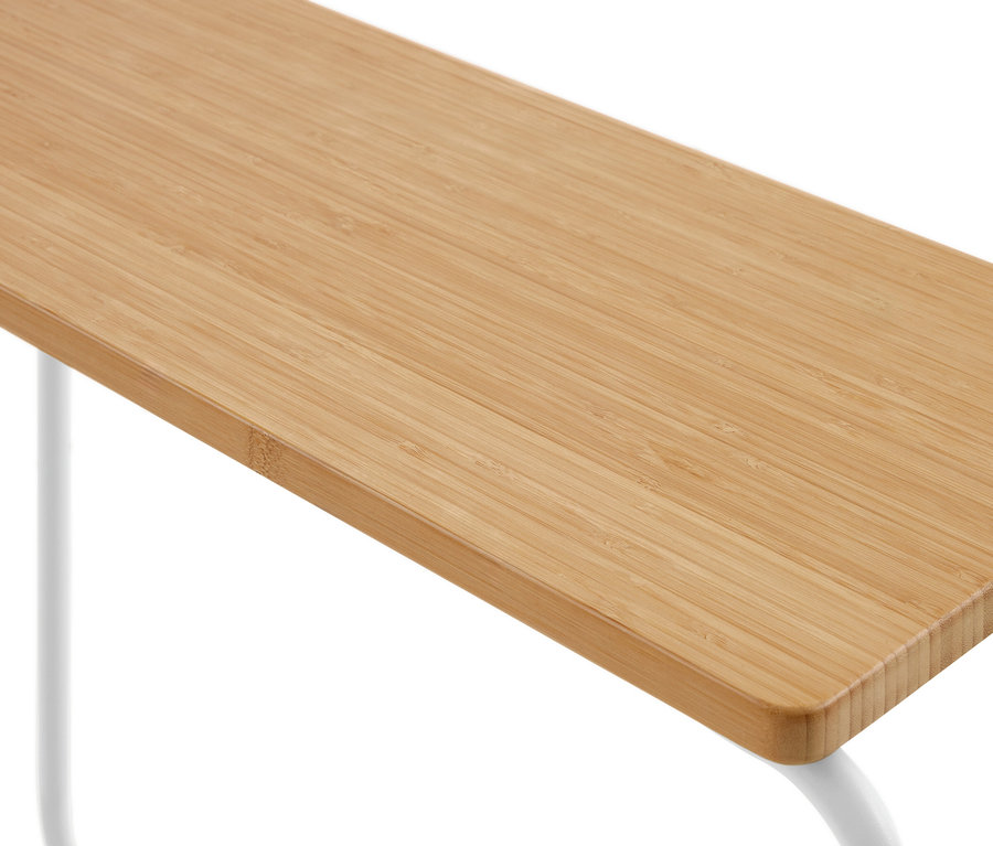 Gros plan d'une surface en bambou brun clair avec un grain visible, soutenue par des pieds blancs incurvés.