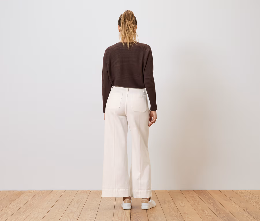 Femme de dos, portant un haut marron foncé et un jean Wide Leg blanc – Fit « Viki ».