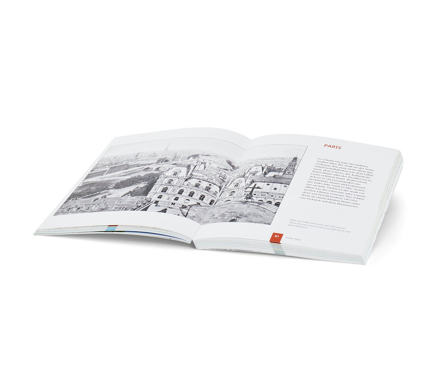 Livre ouvert avec une image en noir et blanc de Paris. Livre : Landkarten-Rätselbuch « Weltreise » (en allemand).