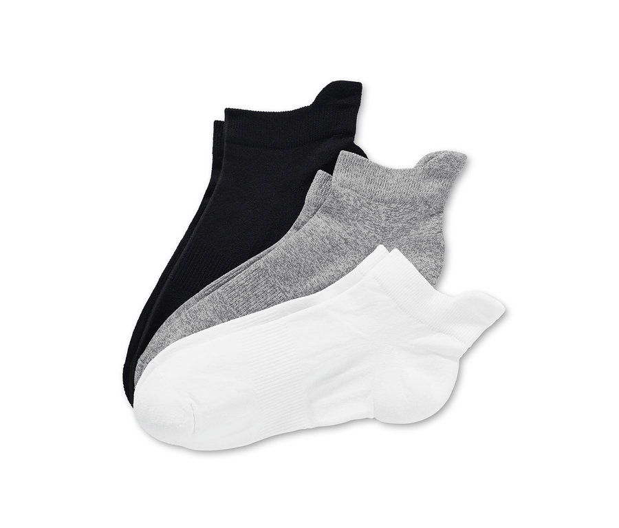 Trois paires de chaussettes de course fonctionnelles en noir, gris et blanc sont superposées.
