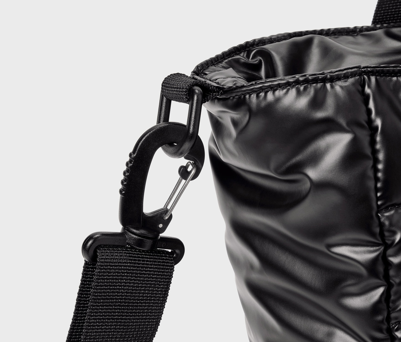 Détail d'un sac noir brillant avec un mousqueton.