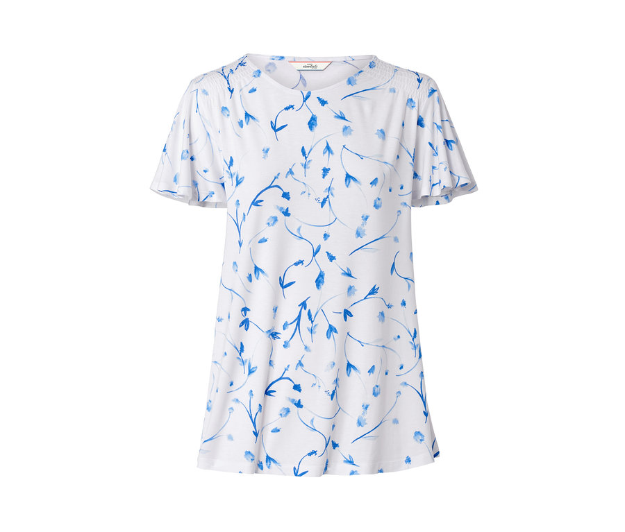 Chemisier blanc avec manches papillon et motif floral bleu.