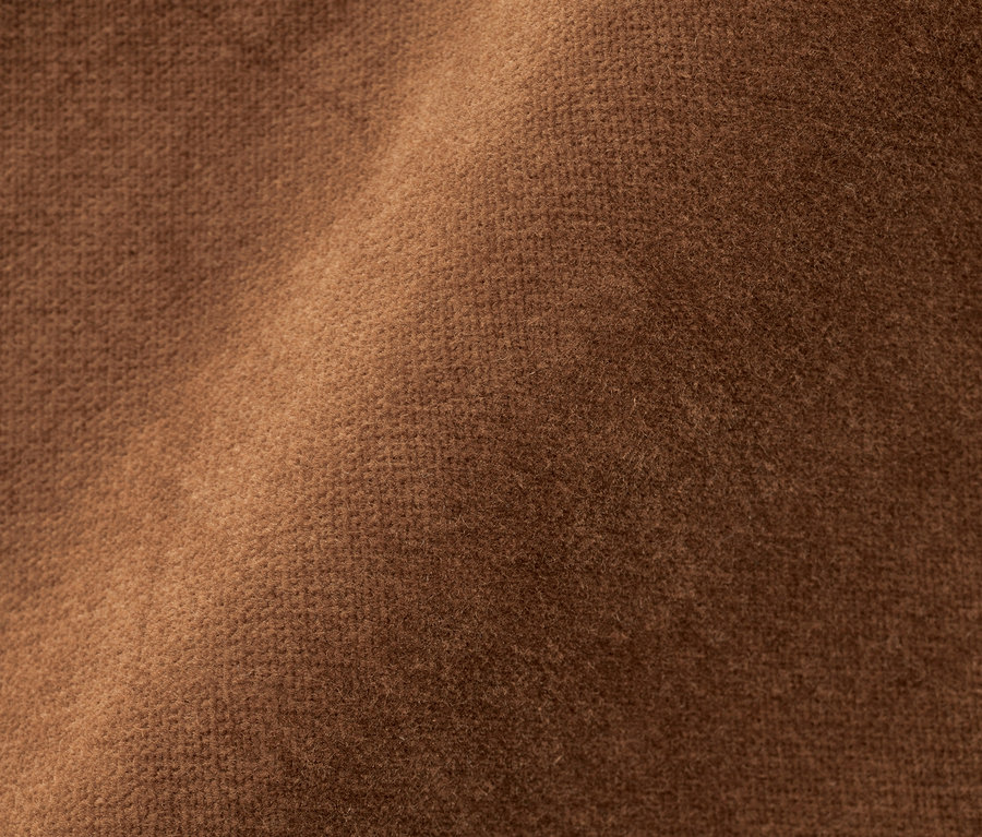 Gros plan d'un pantalon en velours couleur cognac.