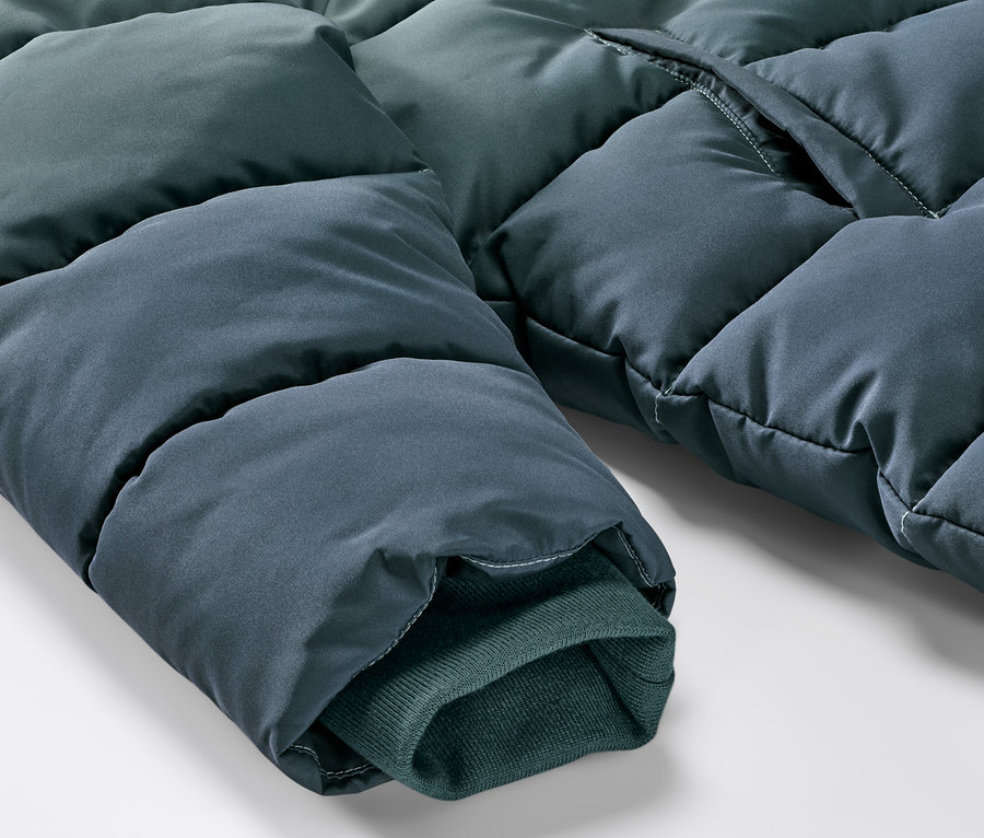 Gros plan sur un manteau thermique pour enfant aux couleurs dégradées, montrant la manche et une partie du corps.