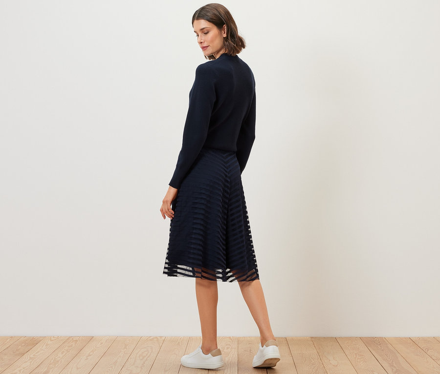 Femme posant en jupe en mesh.