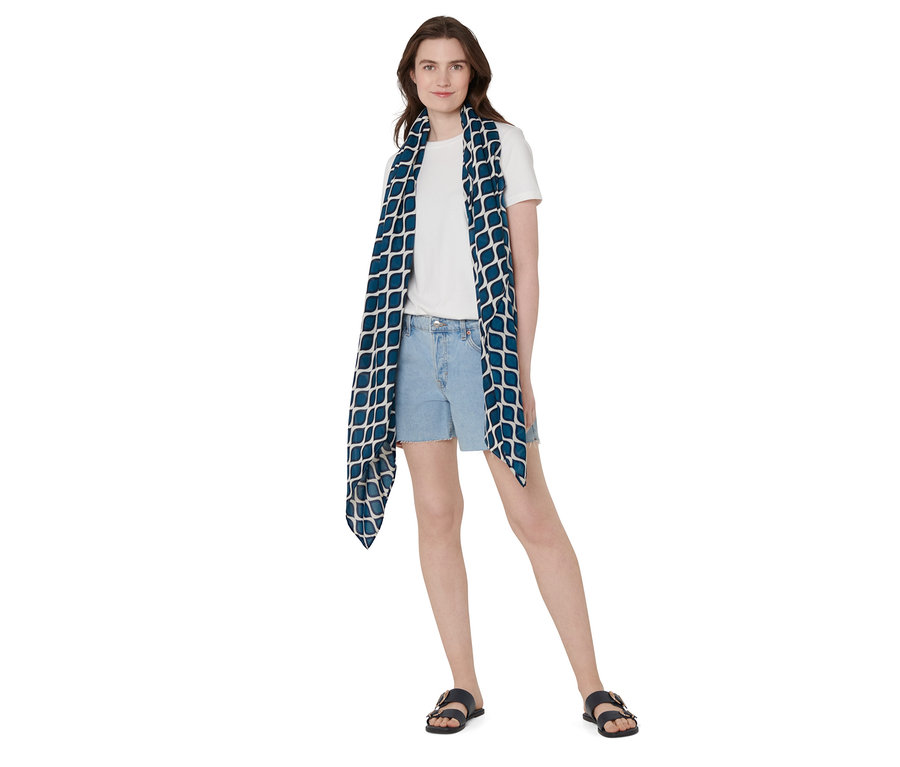 Femme portant un foulard multifonction avec un motif bleu.