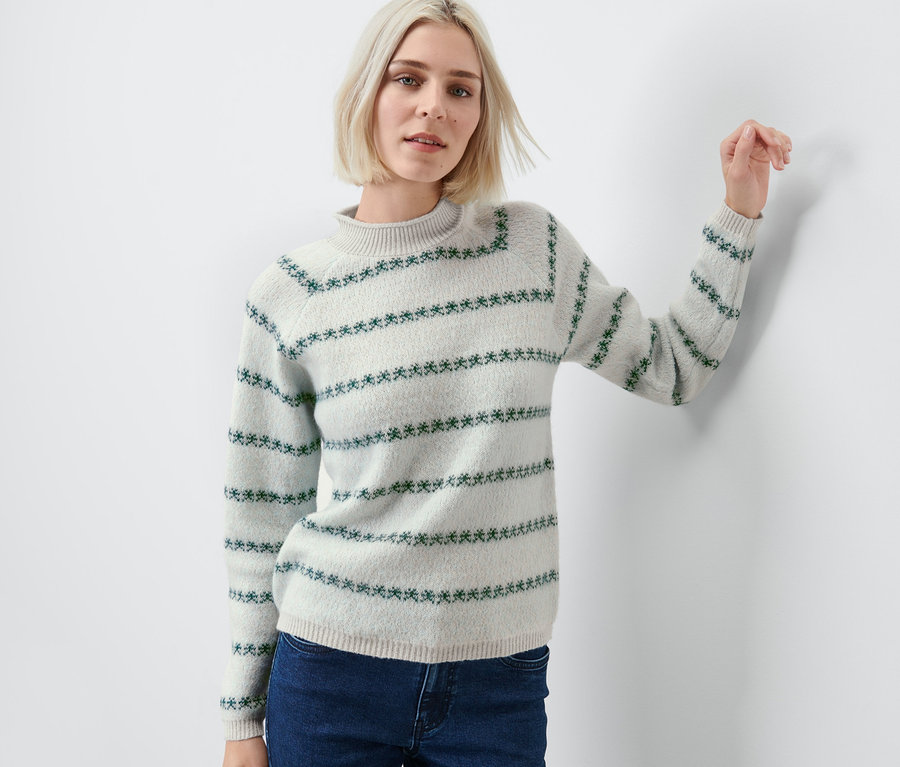 Femme portant un pull en maille avec des motifs bleus.