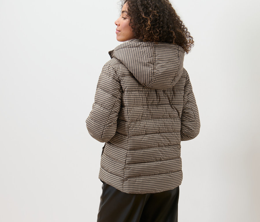 Femme portant une veste matelassée imprimée avec capuche.