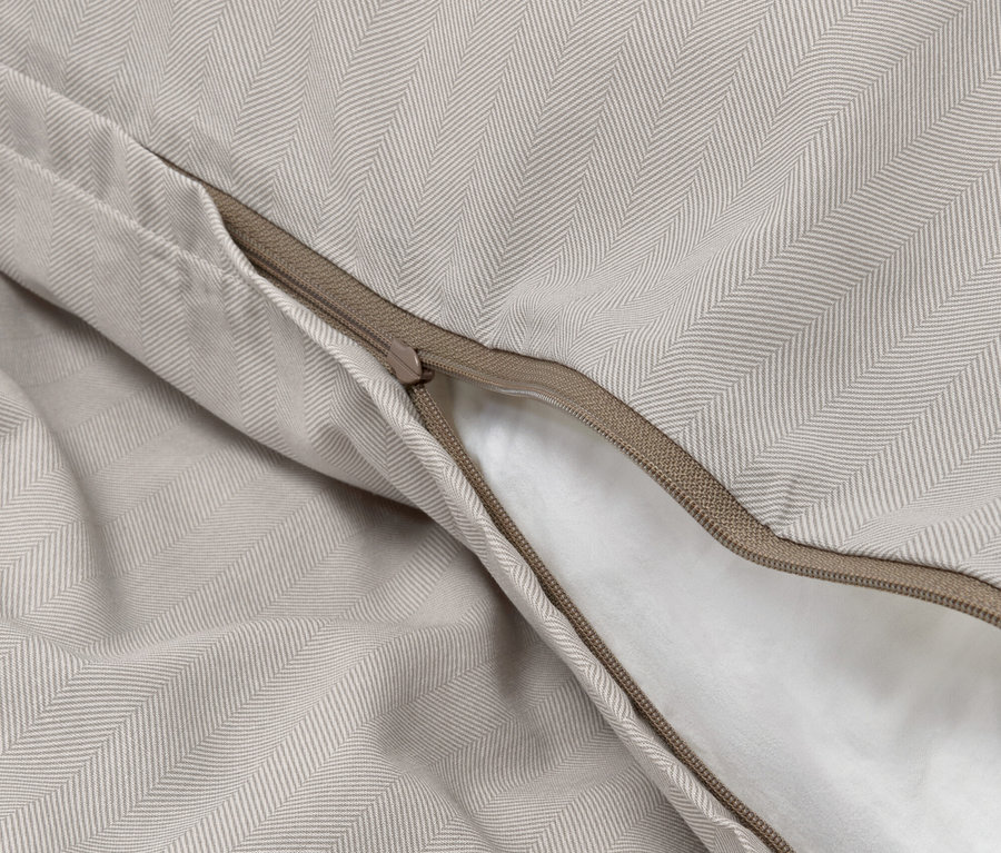 Gros plan d'une parure de lit en flanelle noble avec un motif à chevrons et une fermeture éclair.