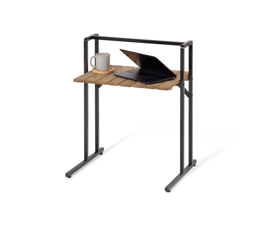 Sur une table en C avec grand plateau se trouvent une tasse grise et un ordinateur portable ouvert.