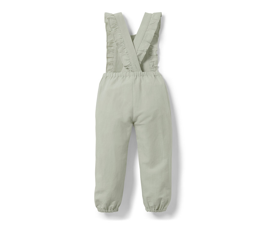 Une combinaison verte pour enfant avec des volants sur les bretelles.