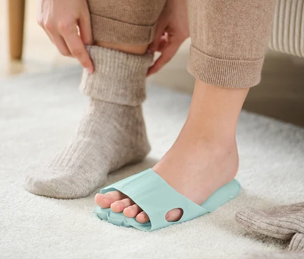 Une personne portant des semelles de relaxation ajuste une chaussette.