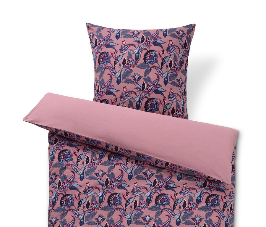 Parure de lit rose en jersey d'hiver avec motif floral et oreiller sur le dessus.