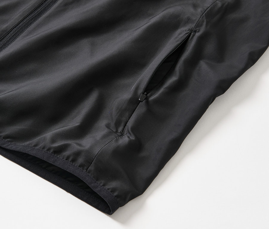 Gros plan sur un gilet technique noir.