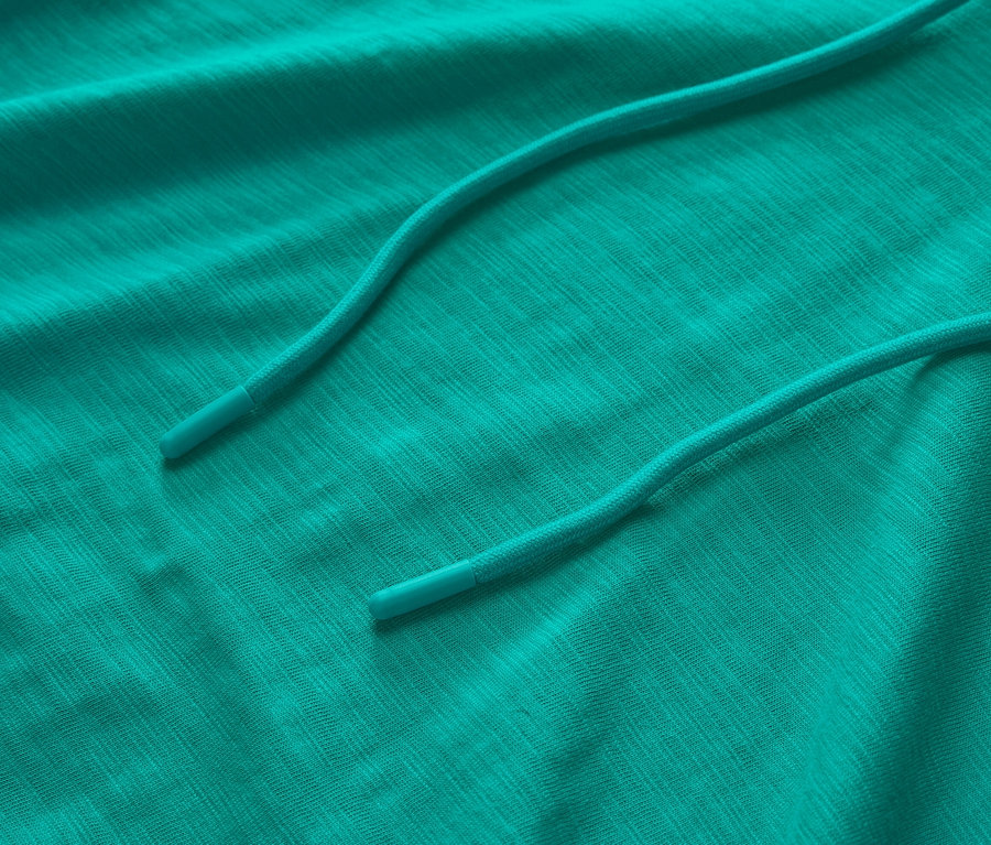 Gros plan sur un sweat à capuche en jersey turquoise avec cordon de serrage.