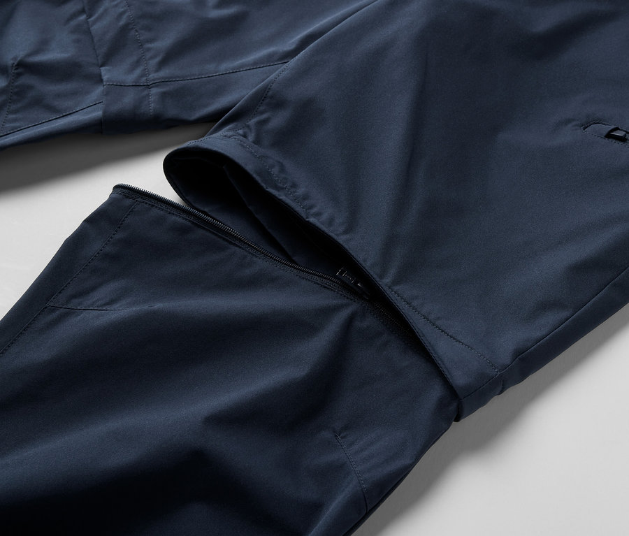 Gros plan sur un pantalon technique 2 en 1 bleu avec fermeture éclair.