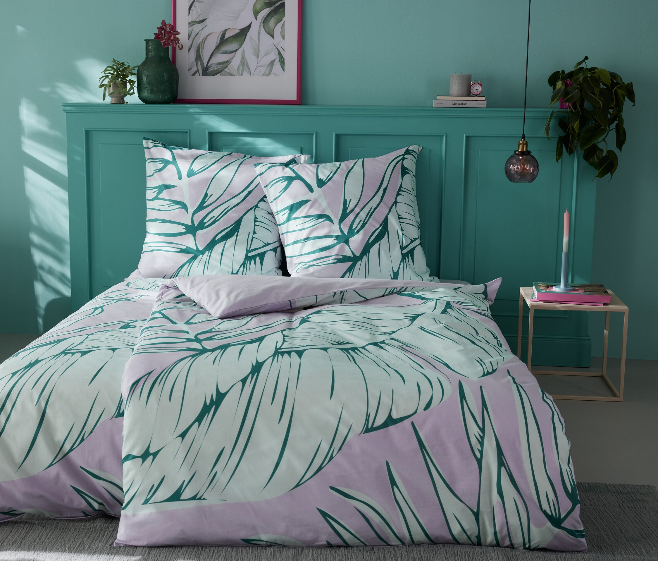 Lit avec parure de lit en renforcé à motif de feuilles.