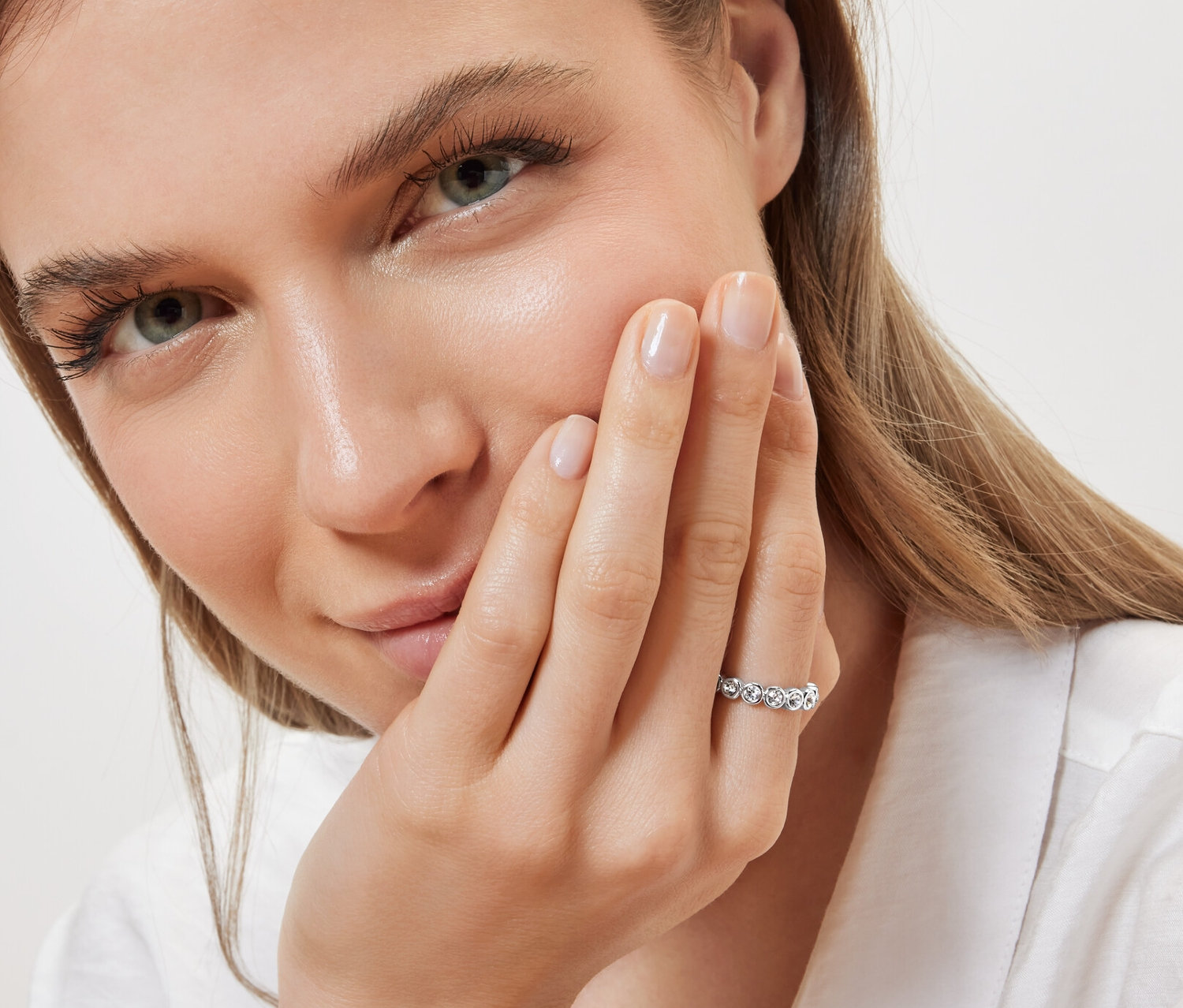 Portrait d'une femme portant une bague mémoire, chrystal à l'annulaire de la main gauche.