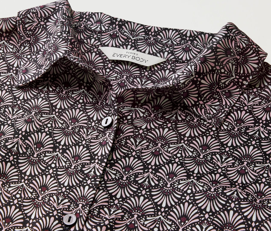 Gros plan d'une chemise de nuit tissée à motif floral noir et blanc avec des boutons.