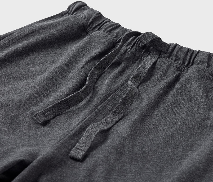 Détail d'un pantalon de pyjama gris avec cordon de serrage.