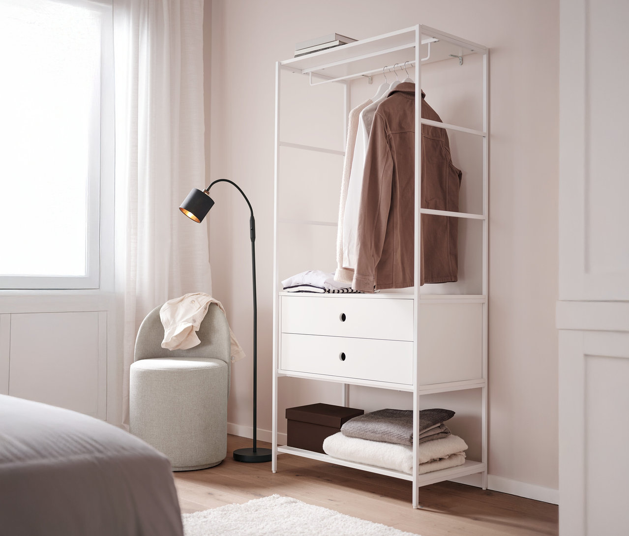 Un tabouret pivotant avec dossier se trouve à côté d'une penderie «
KLAAR
» blanche avec 2 tiroirs dans une chambre.