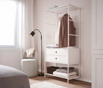 Un tabouret pivotant avec dossier se trouve à côté d'une penderie «
KLAAR
» blanche avec 2 tiroirs dans une chambre.