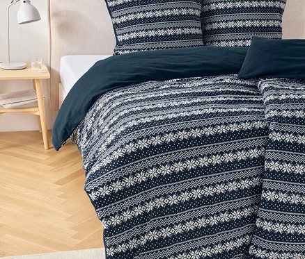 Literie avec motif de Noël sur un lit.