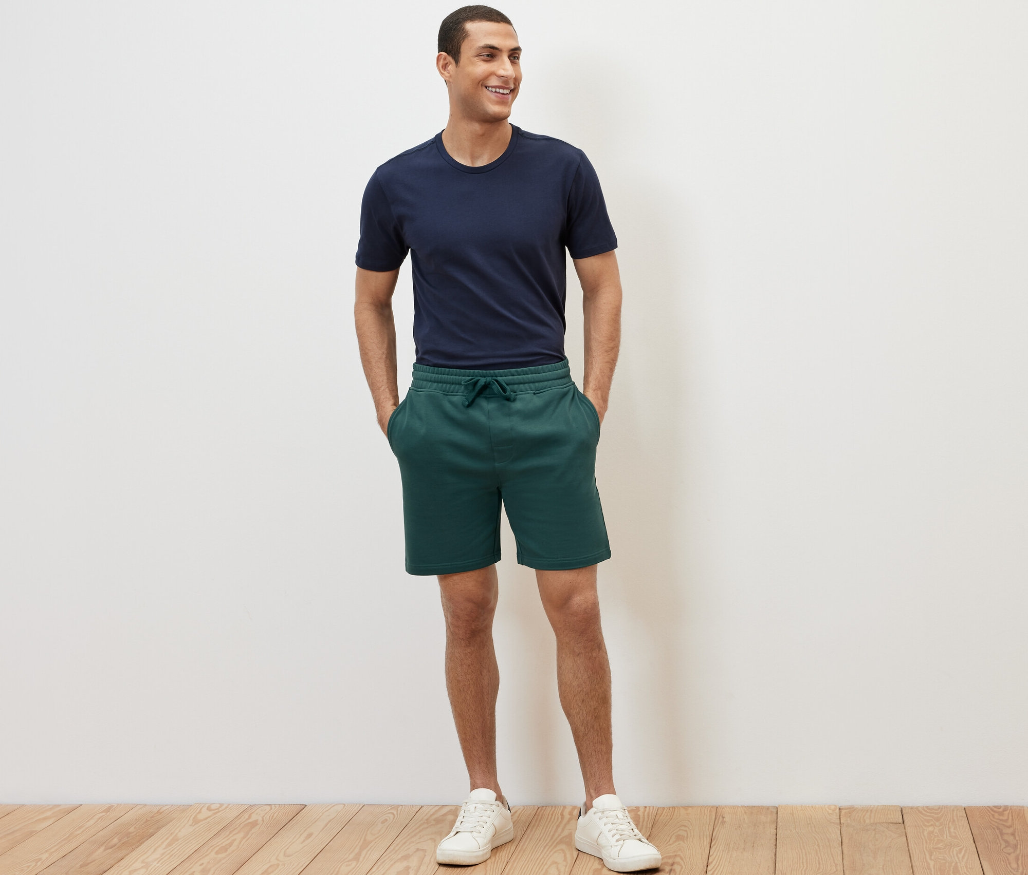 Homme posant en short molletonné.