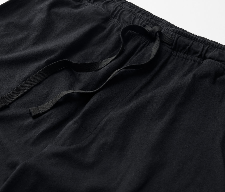 Gros plan sur un pantalon de pyjama noir faisant partie d'un ensemble de pyjama.