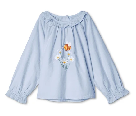 Chemisier bleu clair à manches longues avec broderie de marguerites et d'abeilles.