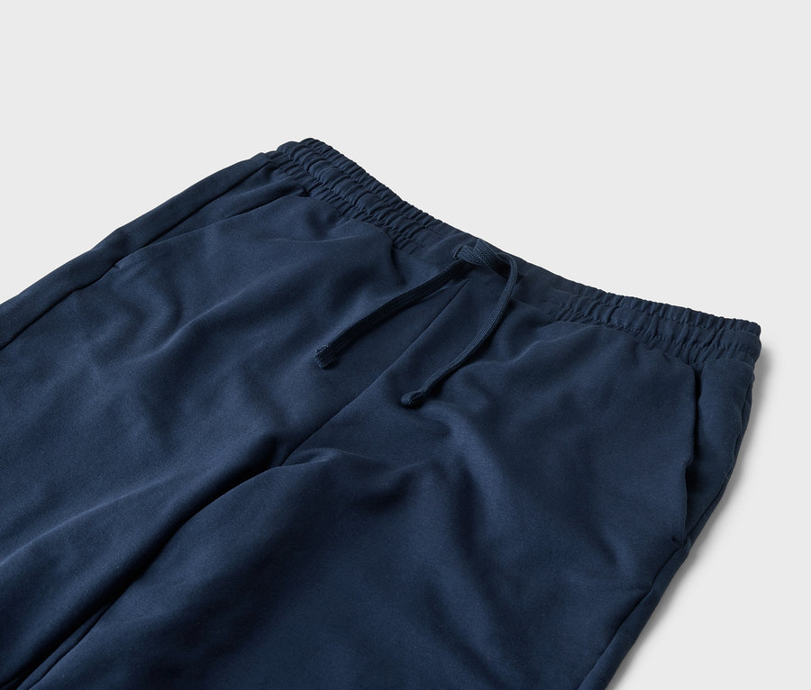 Gros plan d'un pantalon de jogging bleu marine avec cordon de serrage et poches.