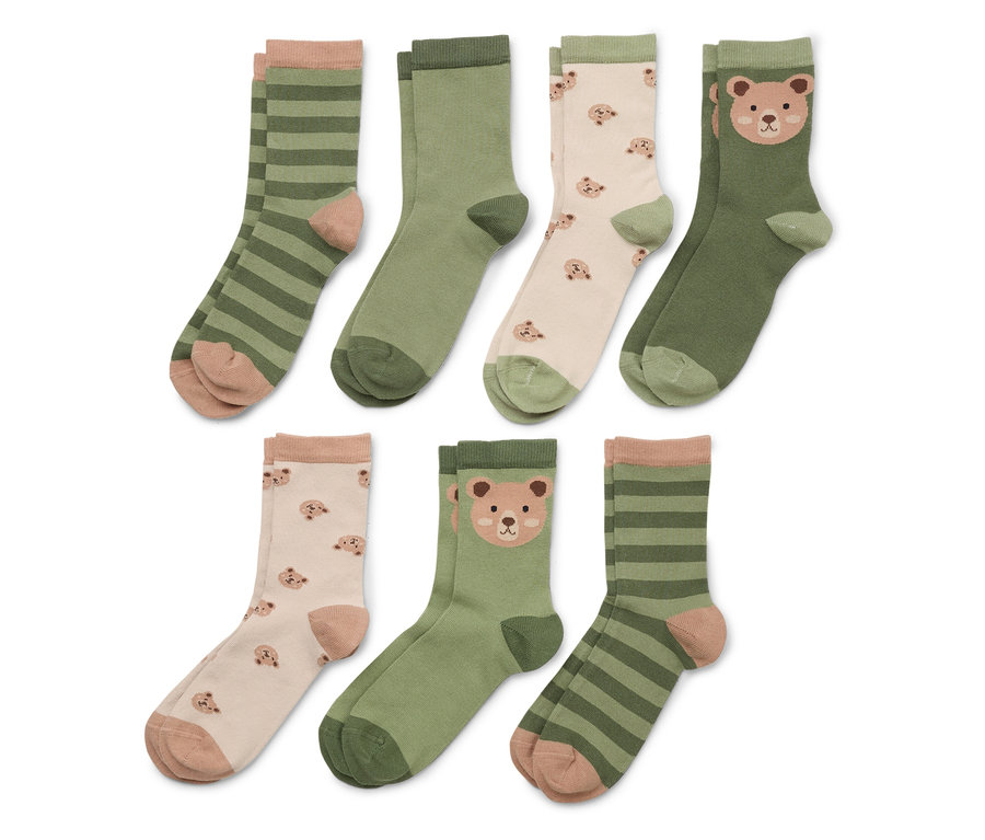 Six paires de chaussettes sont alignées. Les chaussettes sont vertes rayées, vertes unies ou décorées de têtes d'ours.