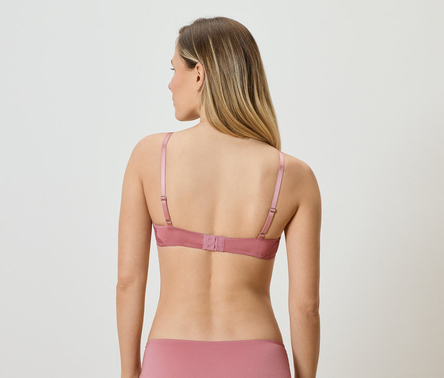Vue arrière d'une femme blonde portant un soutien-gorge rose et une culotte assortie.