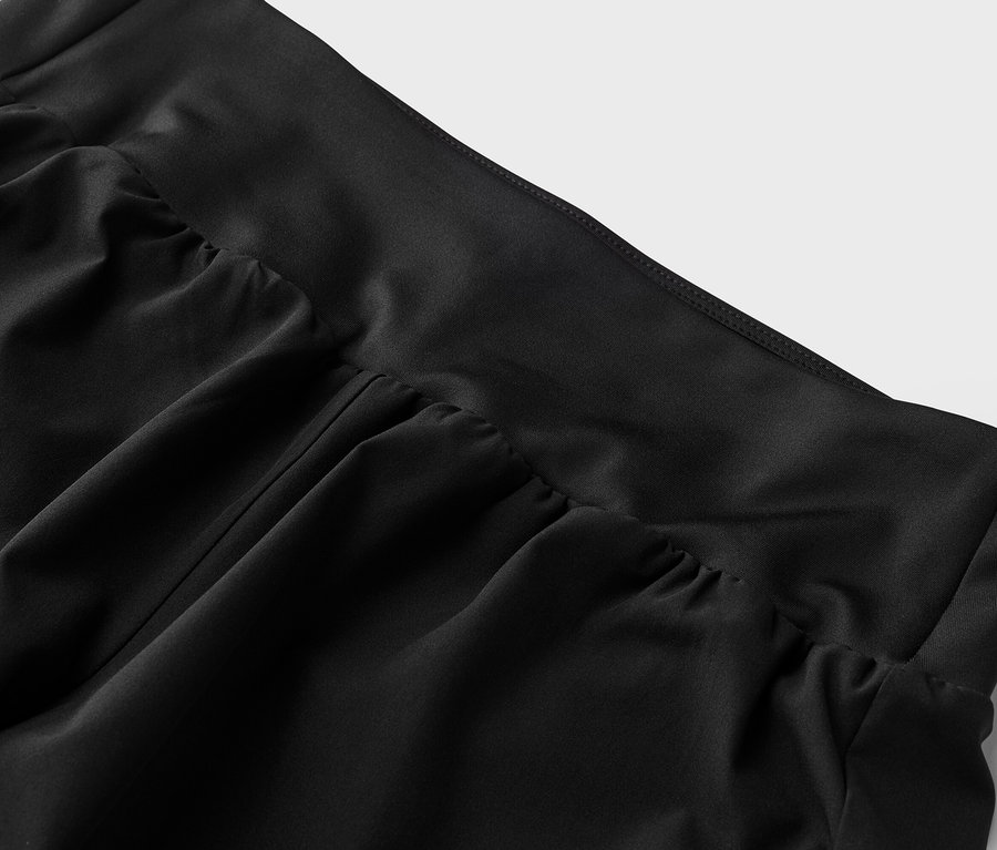 Gros plan d'un tissu noir avec des détails froncés à la taille.