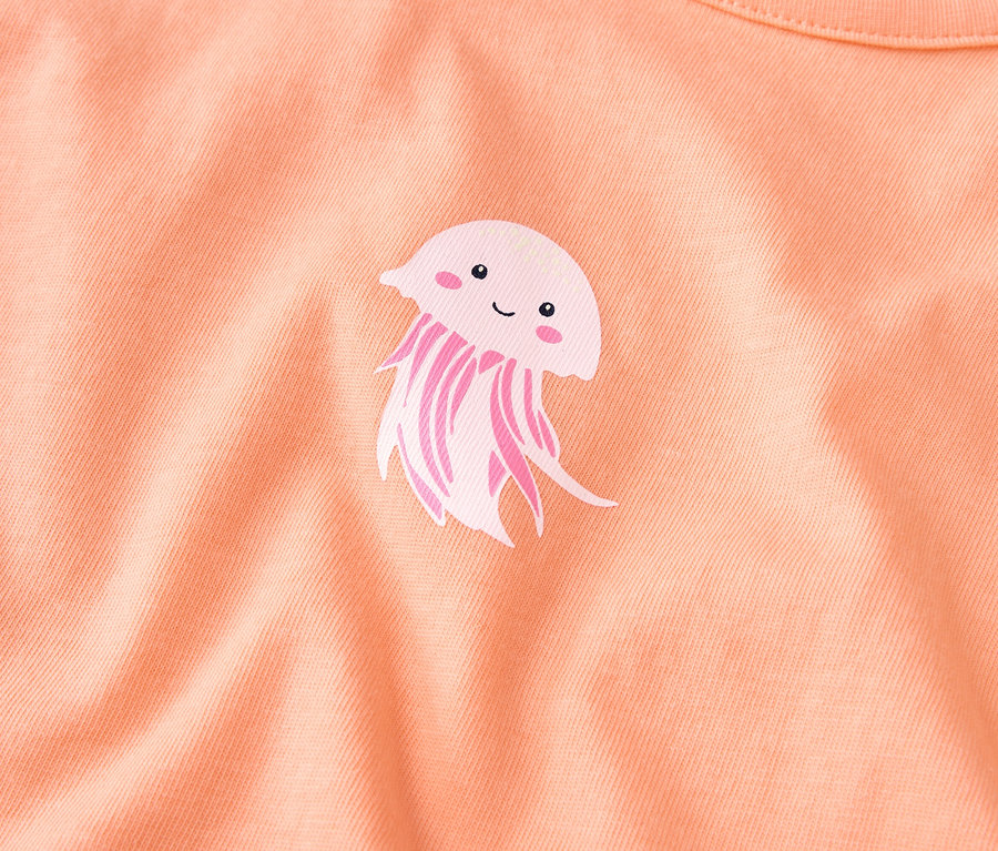 Sur un tissu couleur saumon figure une adorable méduse.
