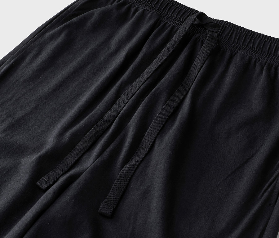 Gros plan d'un pantalon noir avec cordon de serrage et taille élastique.